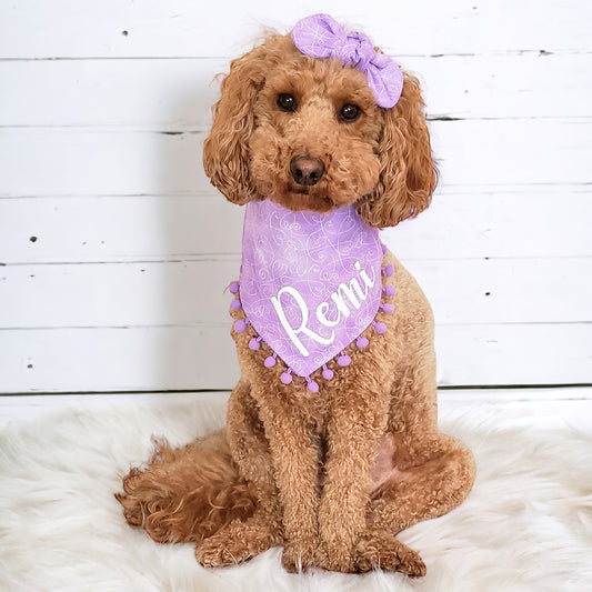 Small dog wearing personalized lavender floral dog bandana with pom poms – cute and handmade pet accessory